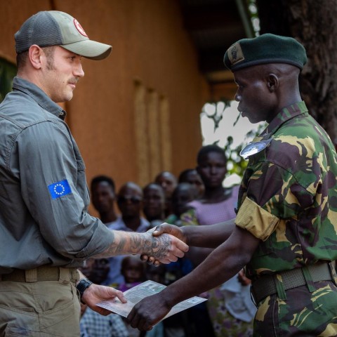 Connor Tovey shaking a Garamba ranger's hand while handing a certificate